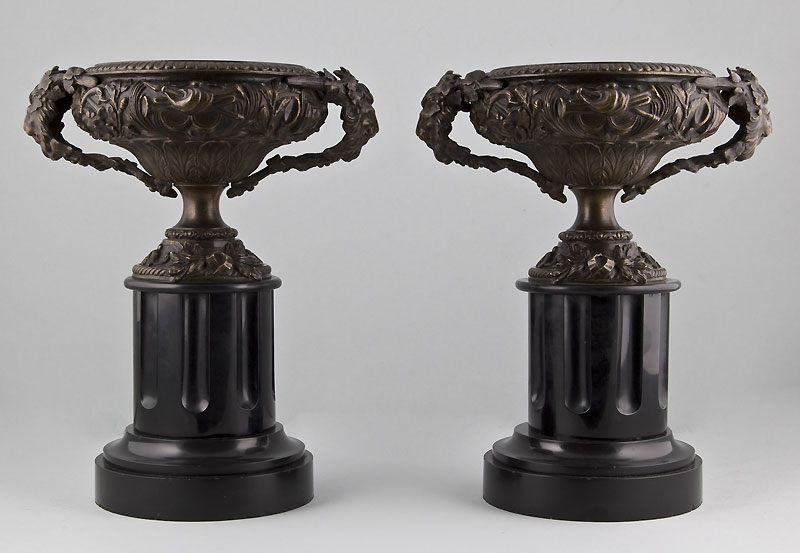 Pair of late Victorian bronze vases on black marble columns.