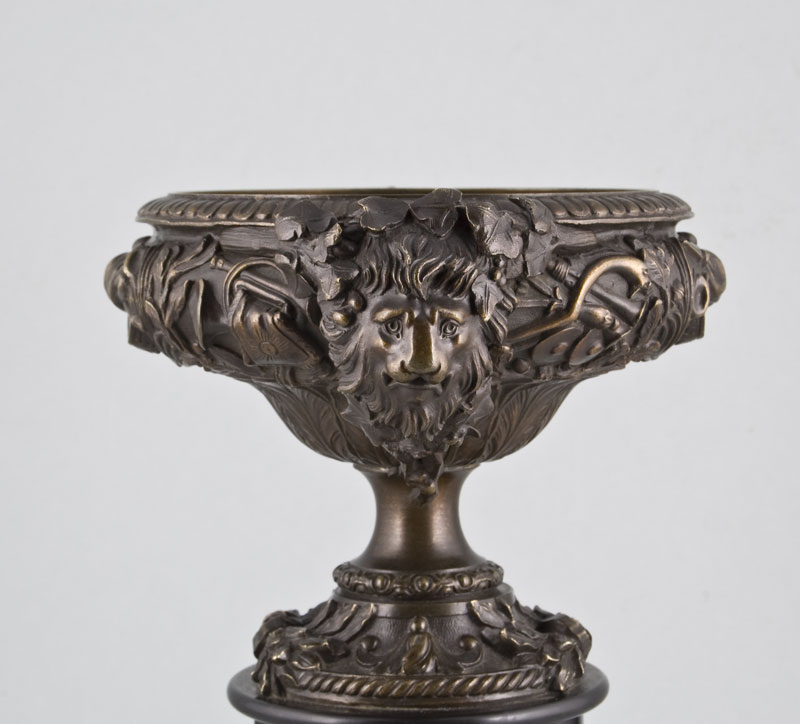 Pair of late Victorian bronze vases on black marble columns.