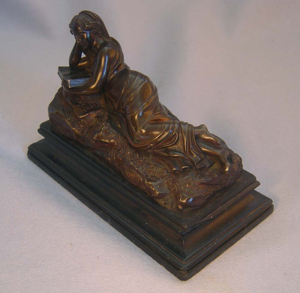 Antique bronze of reclining woman reading book set on a marble base.