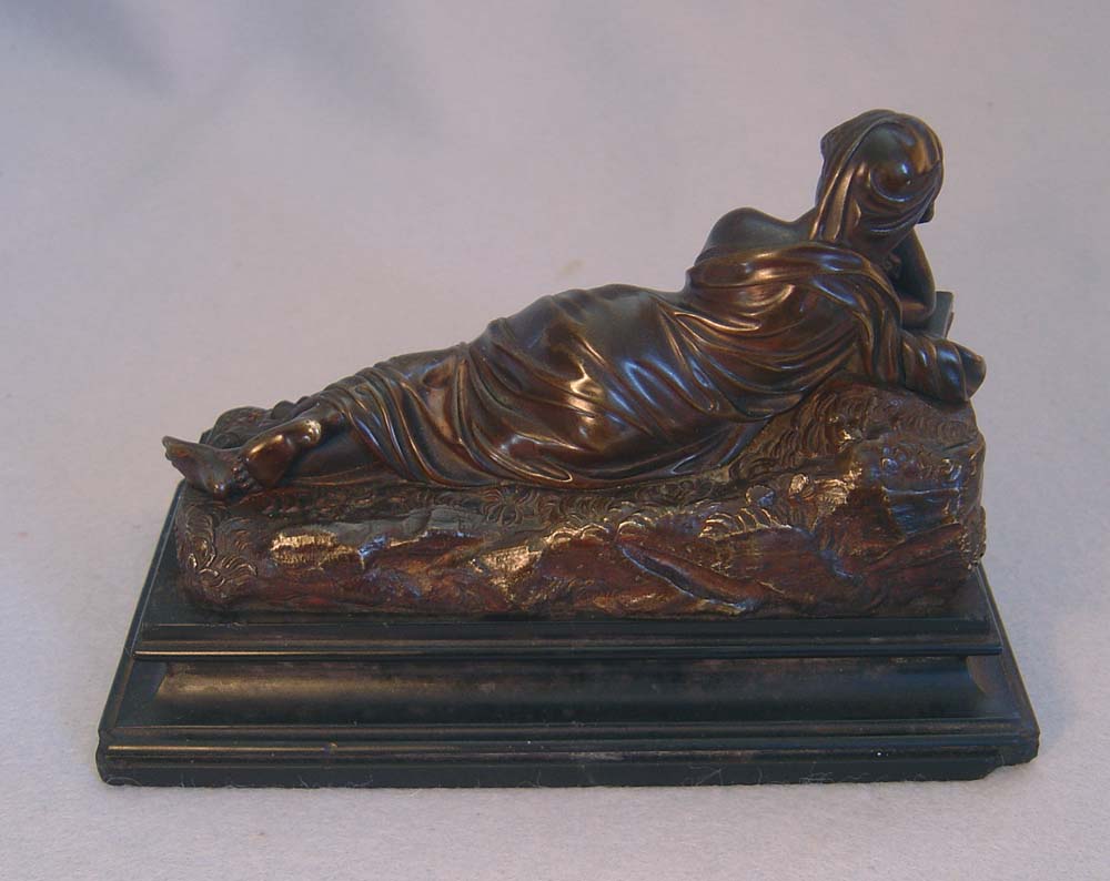 Antique bronze of reclining woman reading book set on a marble base.