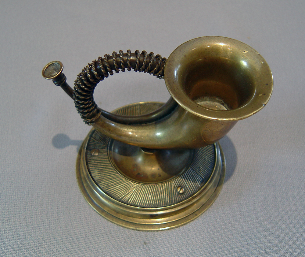Horn match strike in patinated bronze.