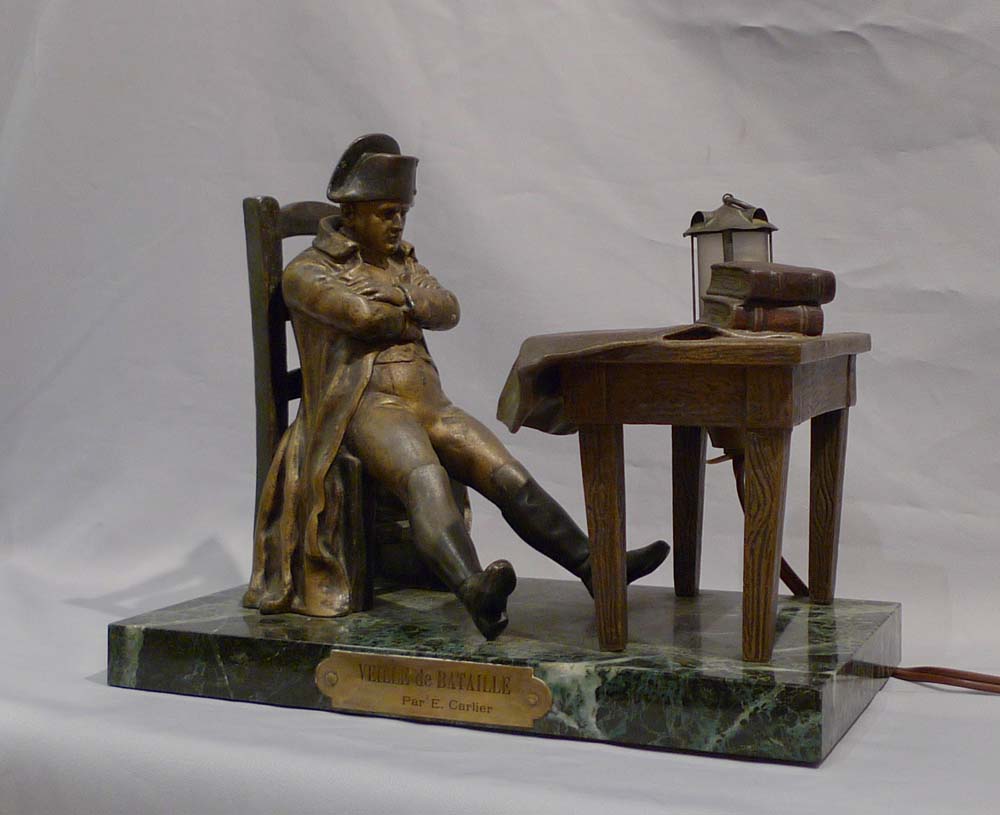 Antique Napoleon Bonaparte figural lamp showing Napoleon seated at a table.