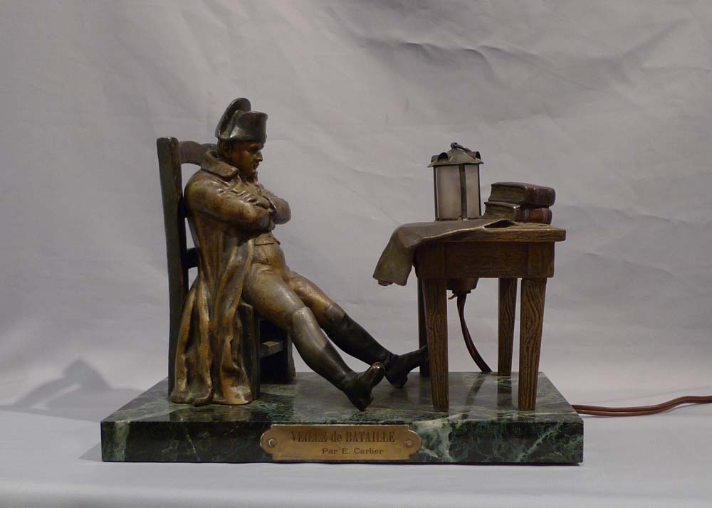 Antique Napoleon Bonaparte figural lamp showing Napoleon seated at a table.
