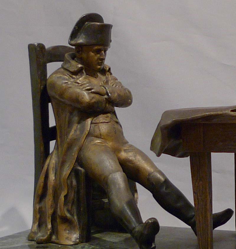 Antique Napoleon Bonaparte figural lamp showing Napoleon seated at a table.