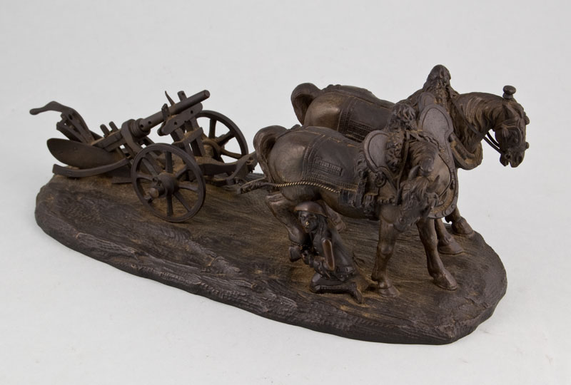 Antique bronze of working horses with plough, tended by groom.