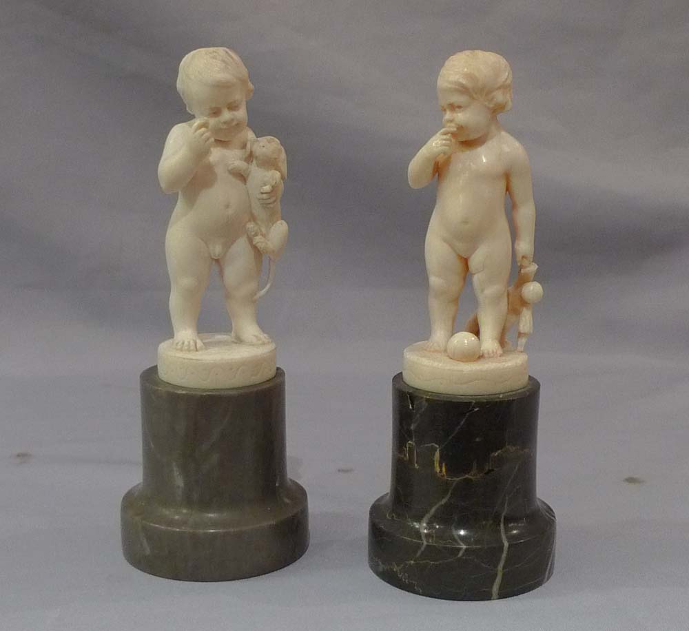 Pair of antique ivory statuettes of children.