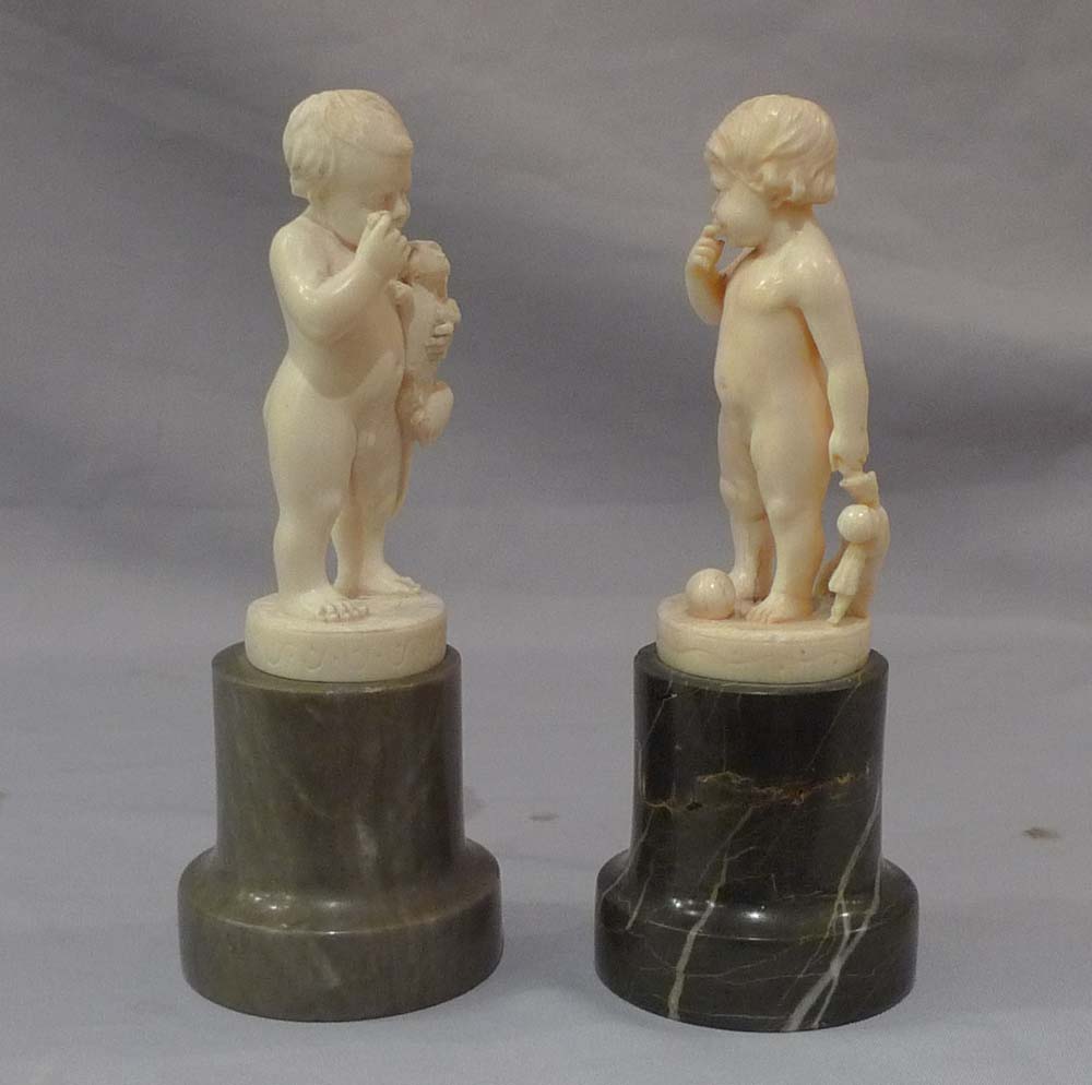 Pair of antique ivory statuettes of children.