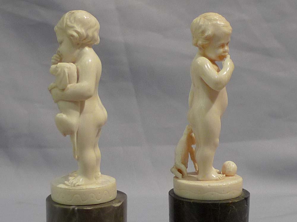 Pair of antique ivory statuettes of children.