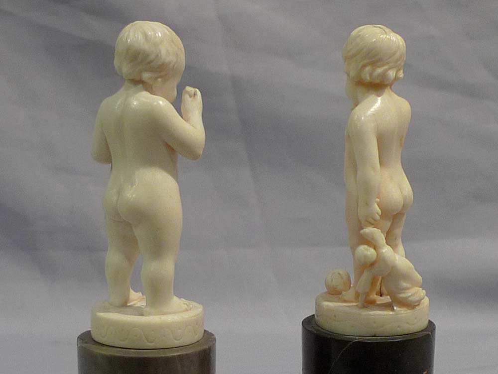 Pair of antique ivory statuettes of children.