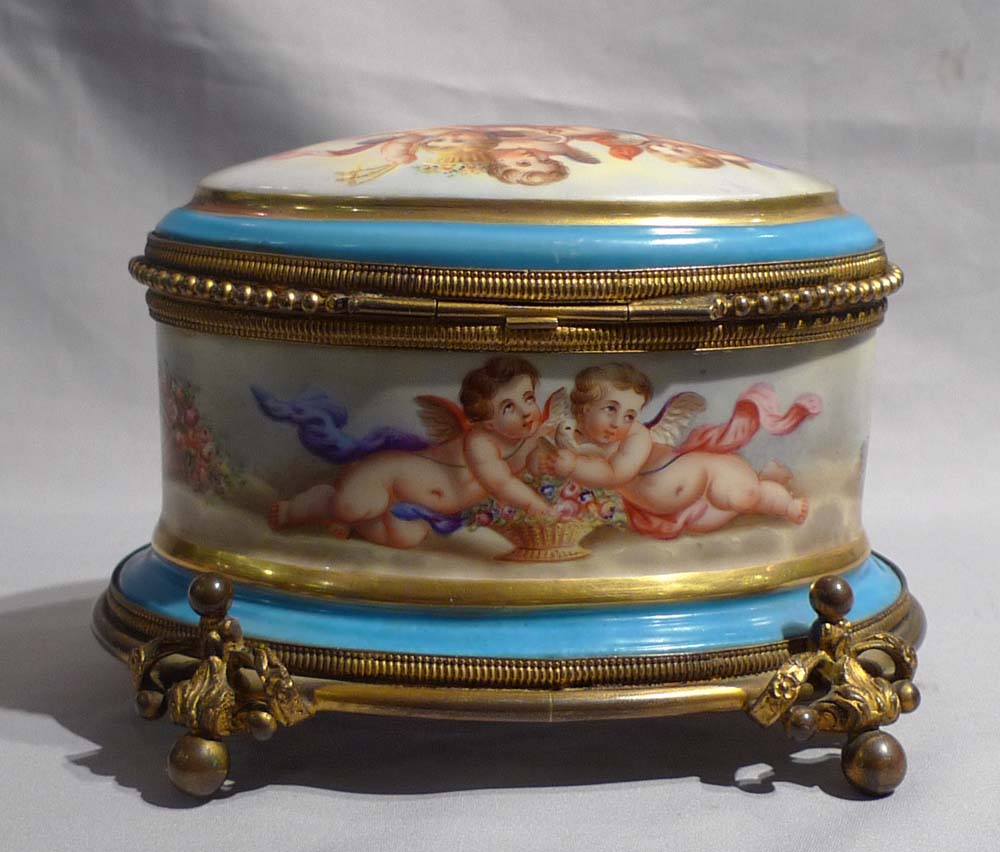 Antique French porcelain and ormolu casket with hand painted scenes of cupids..
