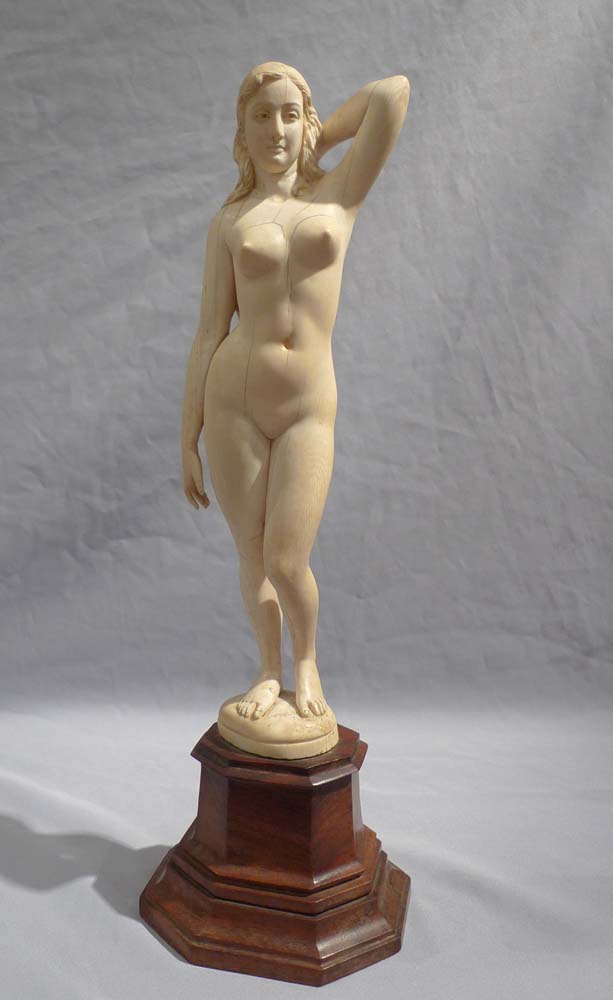 An early 20th century ivory nude on shaped wooden base.