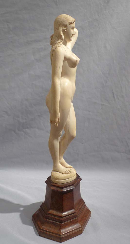 An early 20th century ivory nude on shaped wooden base.