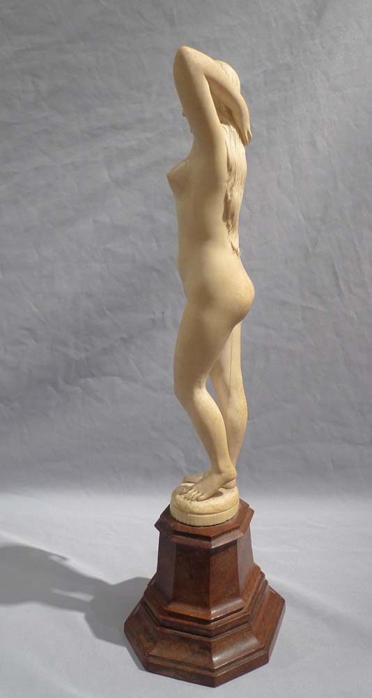 An early 20th century ivory nude on shaped wooden base.