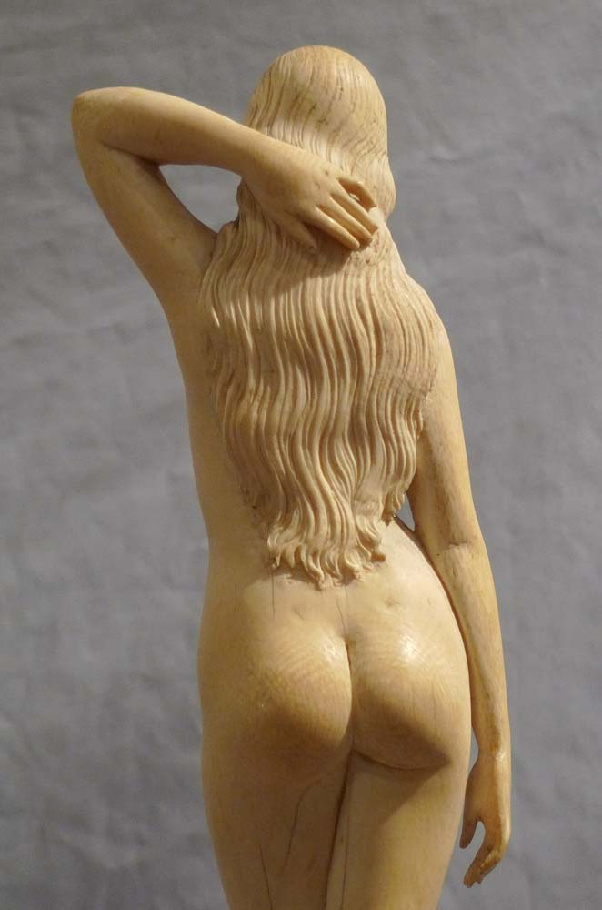 An early 20th century ivory nude on shaped wooden base.