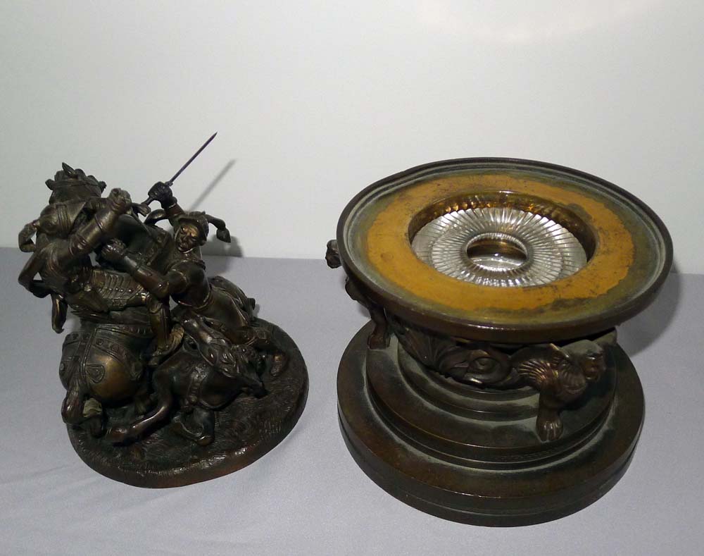 A patinated bronze figural inkwell with the detachable cover applied with Knights fighting on horses