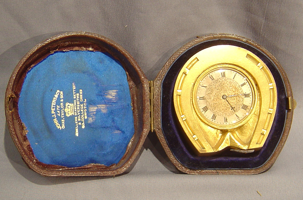 Antique English horseshoe cole style strut clock in original case.