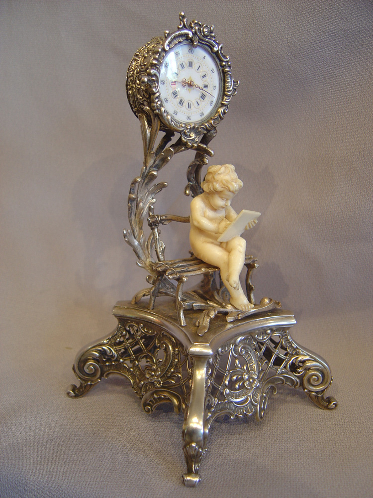 Antique Austrian silver gilt and ivory miniature clock of cupid in a bower.
