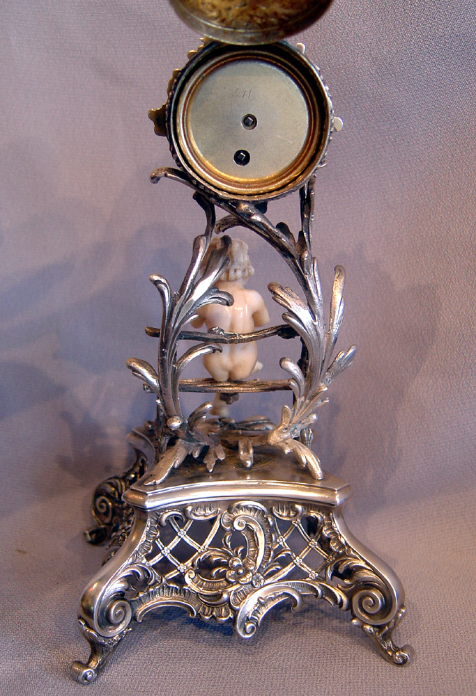 Antique Austrian silver gilt and ivory miniature clock of cupid in a bower.