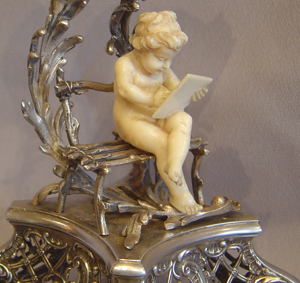 Antique Austrian silver gilt and ivory miniature clock of cupid in a bower.