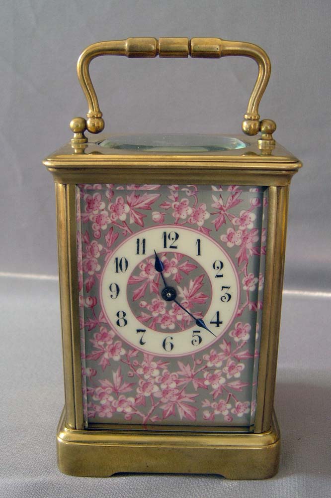 Antique porcelain panelled French carriage clock with apple blossom decoration.