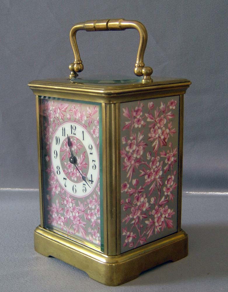 Antique porcelain panelled French carriage clock with apple blossom decoration.