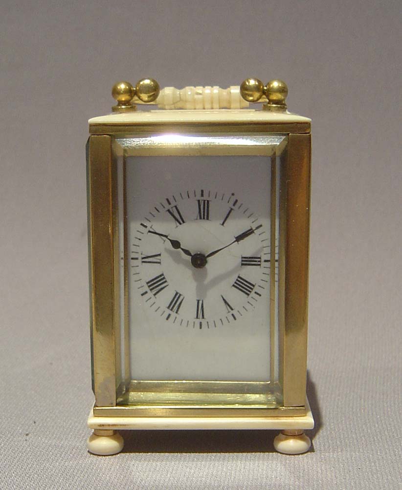 Ivory and gilt bronze carriage clock of small size.