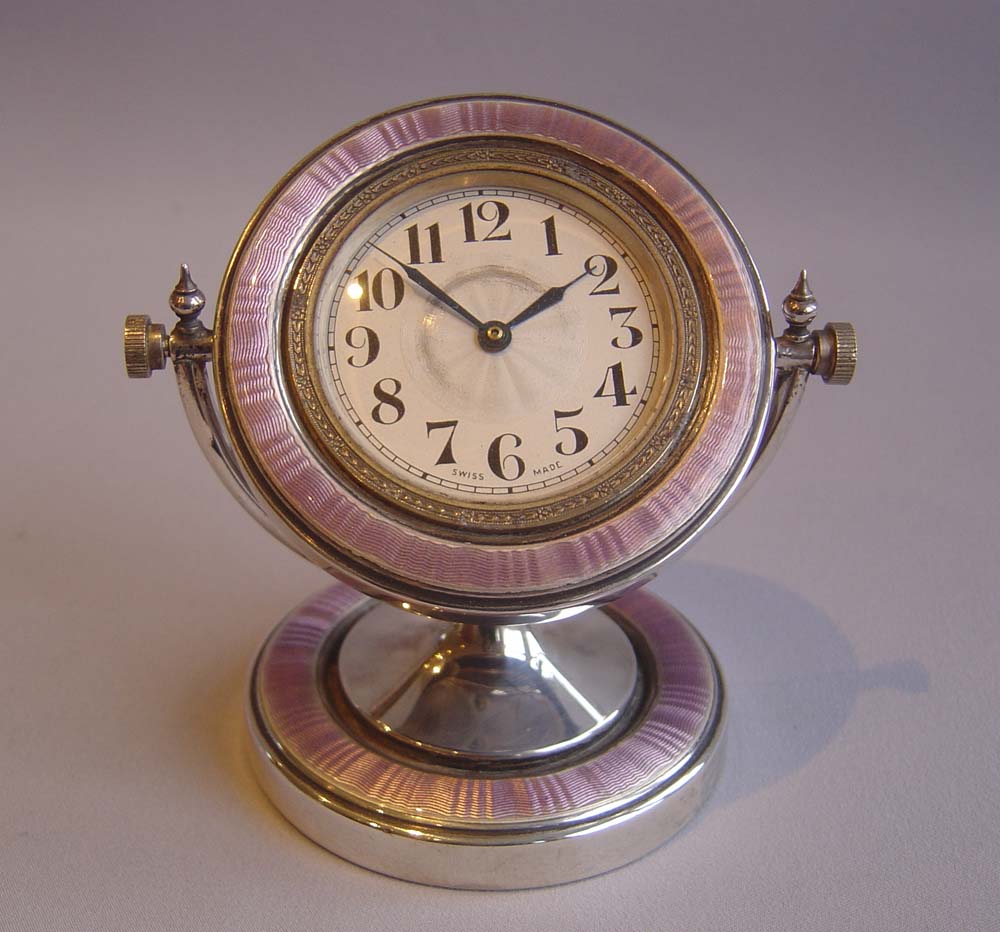 Silver and lilac guilloche enamel garniture of clock and pair of candlesticks..