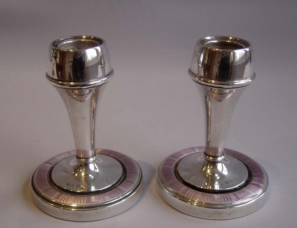 Silver and lilac guilloche enamel garniture of clock and pair of candlesticks..