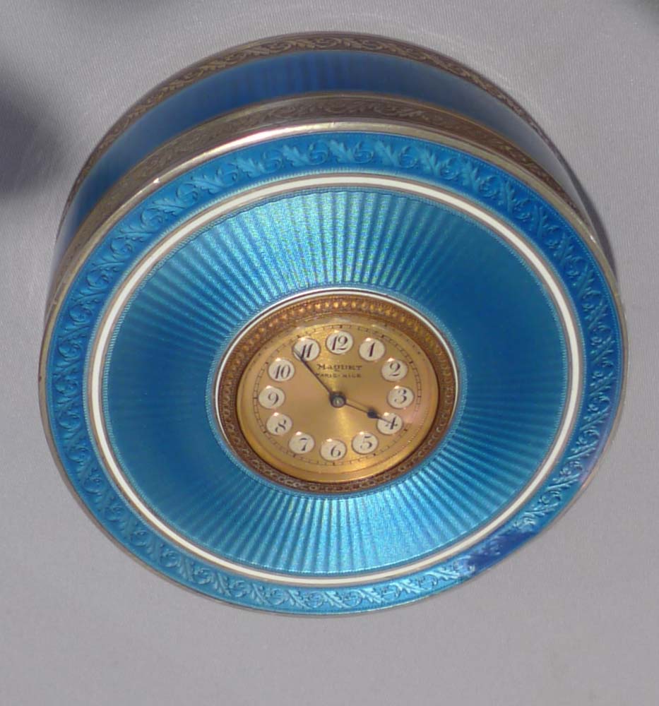 Silver and blue guilloche enamel clock in circular box.