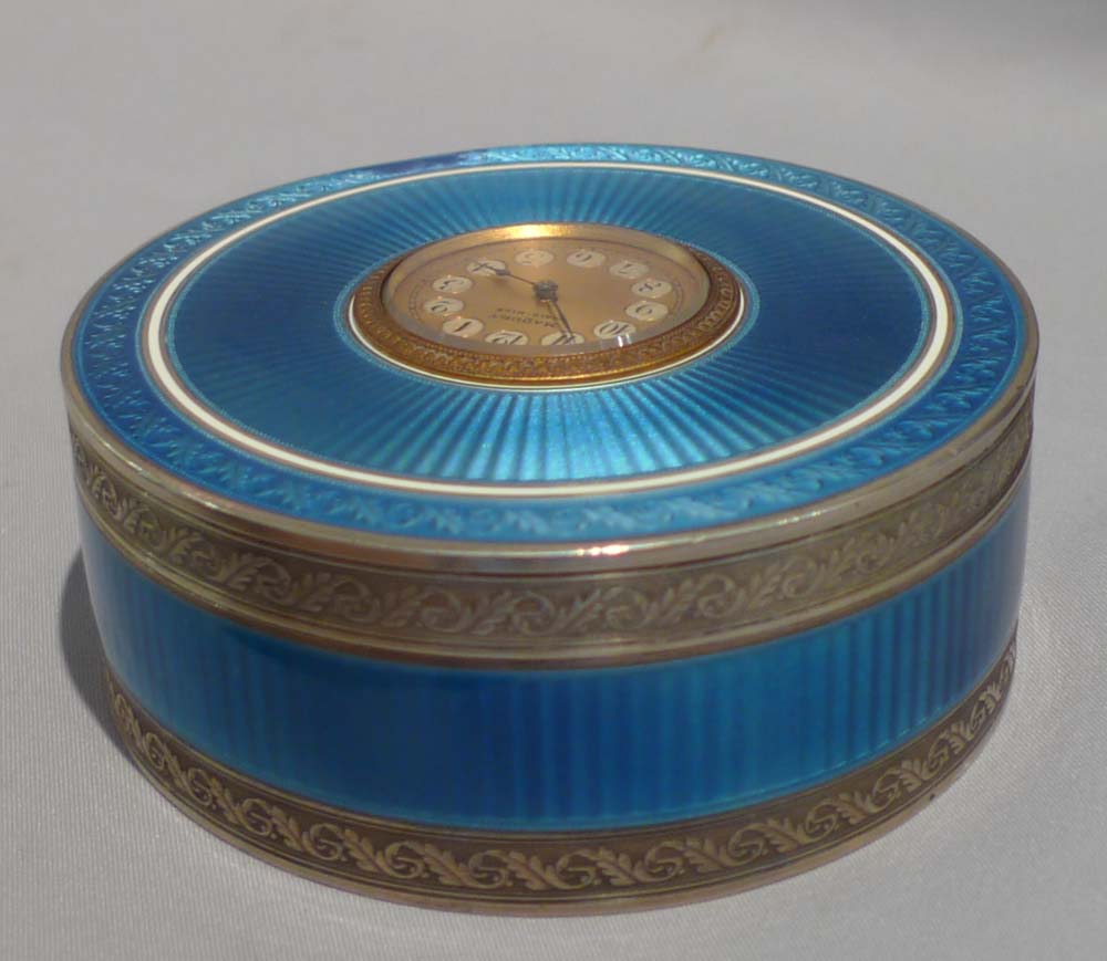 Silver and blue guilloche enamel clock in circular box.