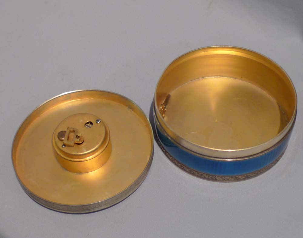 Silver and blue guilloche enamel clock in circular box.