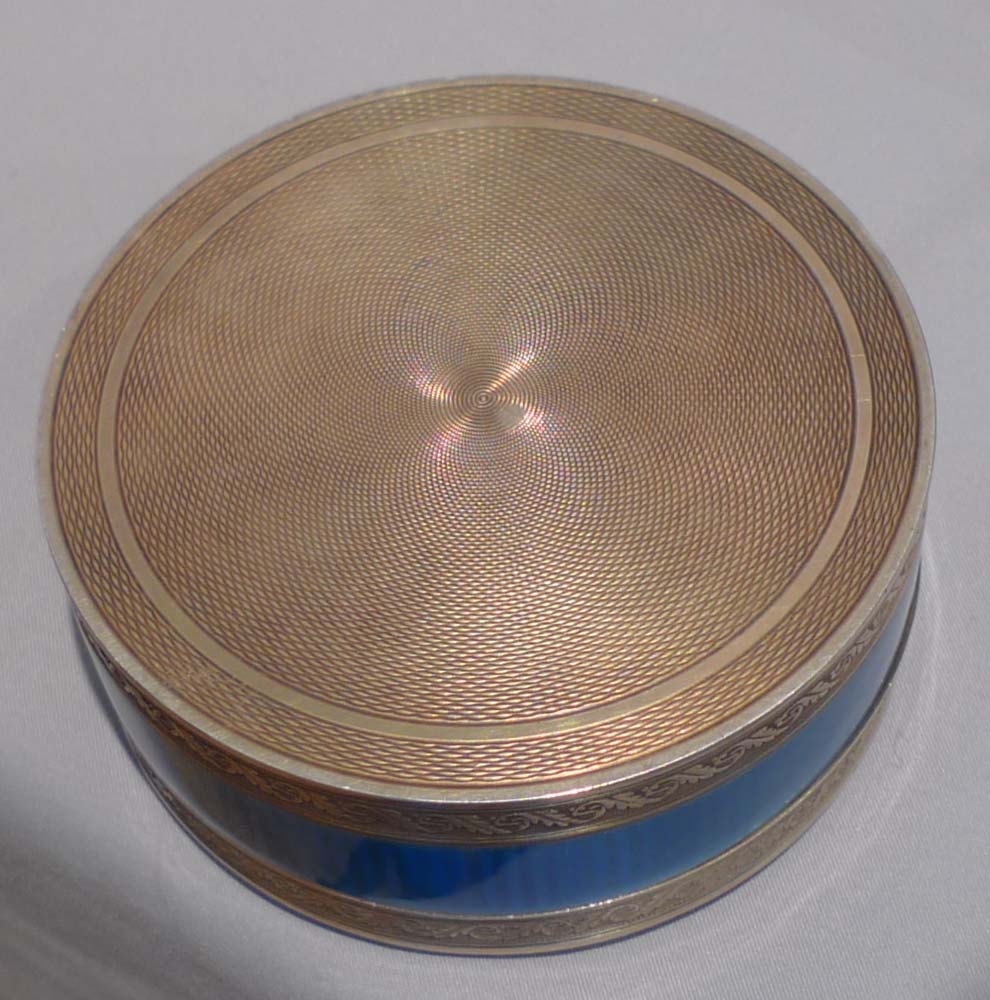 Silver and blue guilloche enamel clock in circular box.