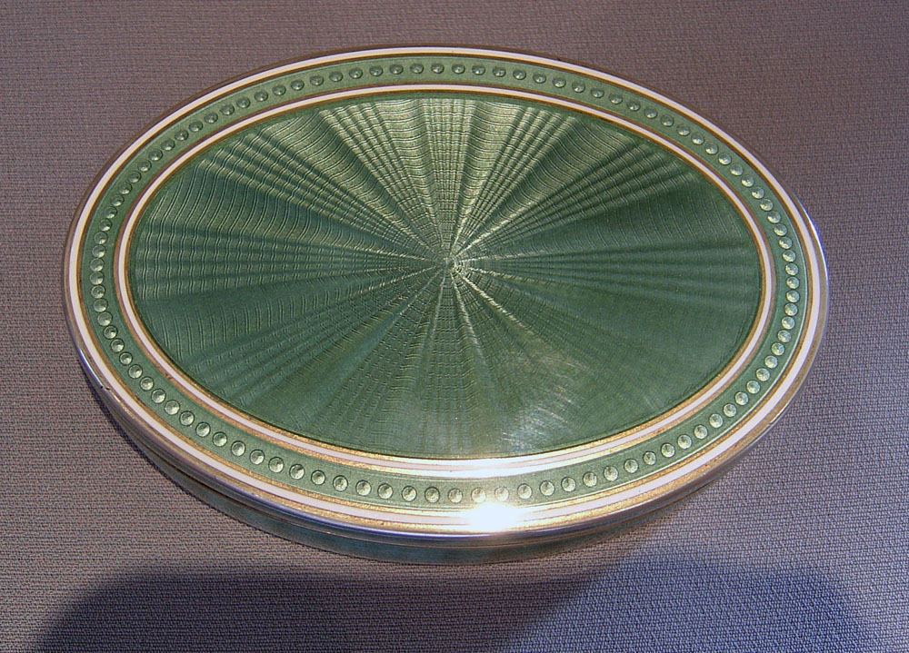 English Edwardian silver gilt and olive green guilloche enamel oval box.