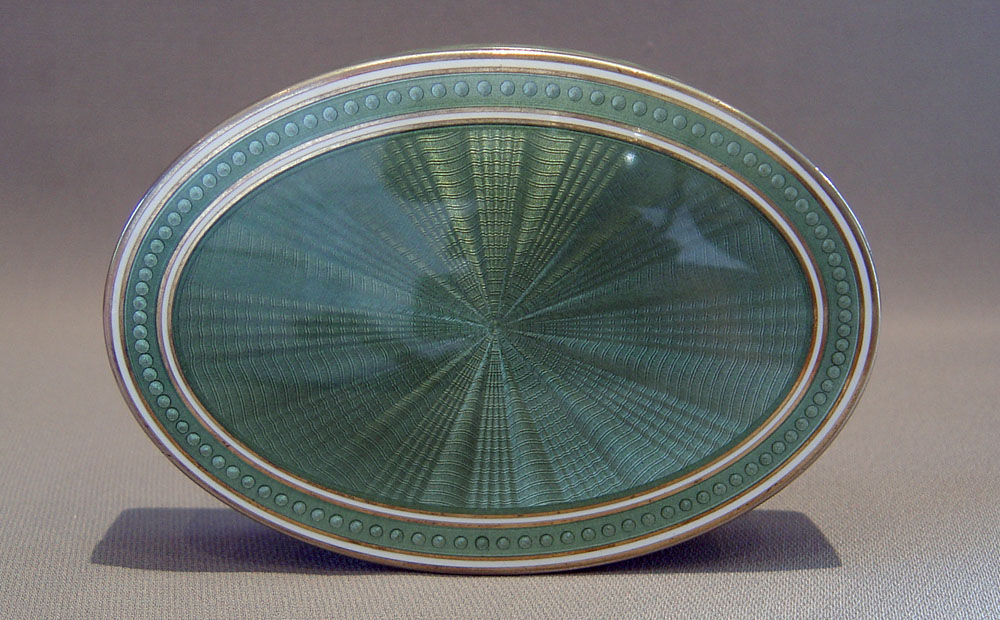 English Edwardian silver gilt and olive green guilloche enamel oval box.