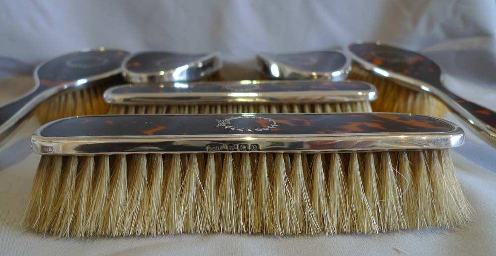 Harlequin set of tortoiseshell, silver piquer and silver brushes and mirror.