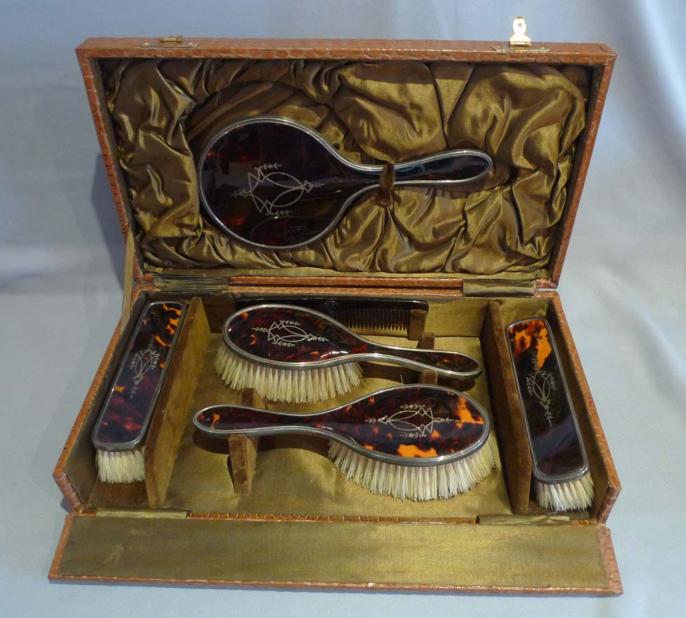 Silver and silver pique tortoiseshell hairbrushes and hand mirror in original case.