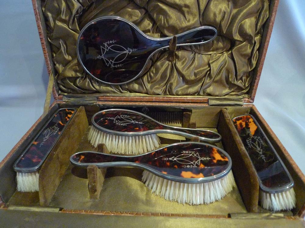 Silver and silver pique tortoiseshell hairbrushes and hand mirror in original case.