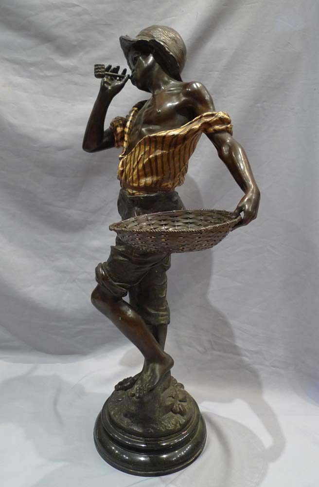 Good sculpture of a black boy smoking a pipe and holding a basket.