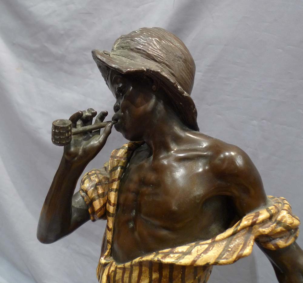 Good sculpture of a black boy smoking a pipe and holding a basket.