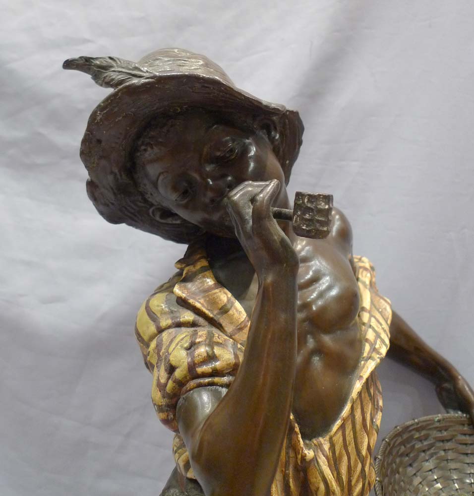Good sculpture of a black boy smoking a pipe and holding a basket.