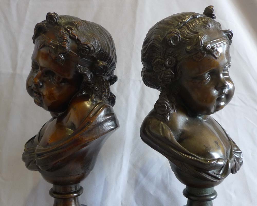 Antique pair of bronze busts of childs' heads on marble bases.
