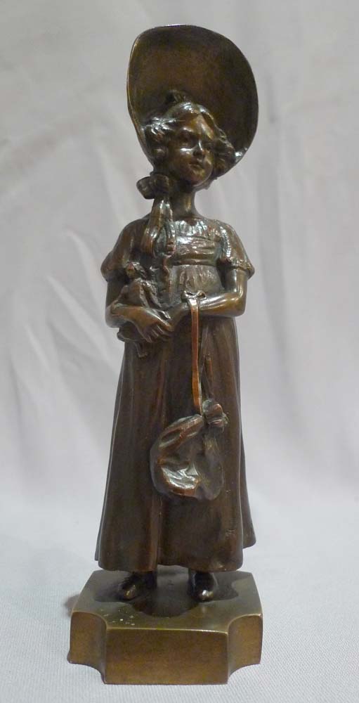 Antique bronze of a young woman in 19th century dress signed P. Kowalczewski.