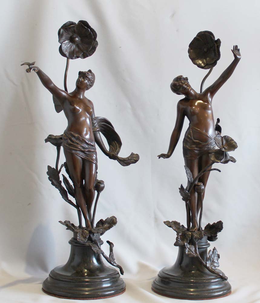 Pair of antique bronzes of nymphs with applied flowers on circular bases.