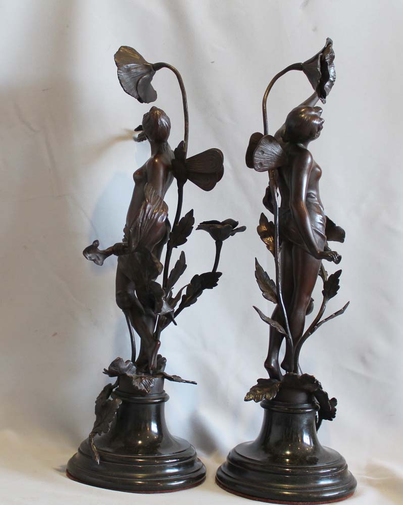 Pair of antique bronzes of nymphs with applied flowers on circular bases.