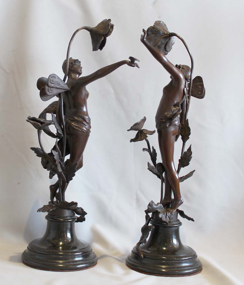 Pair of antique bronzes of nymphs with applied flowers on circular bases.
