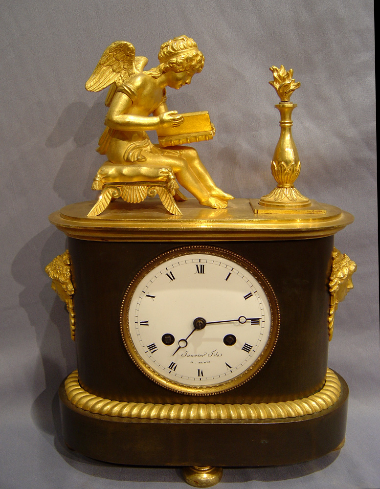 Antique French Empire patinated bronze and ormolu clock of boot shape of Cupid studying.