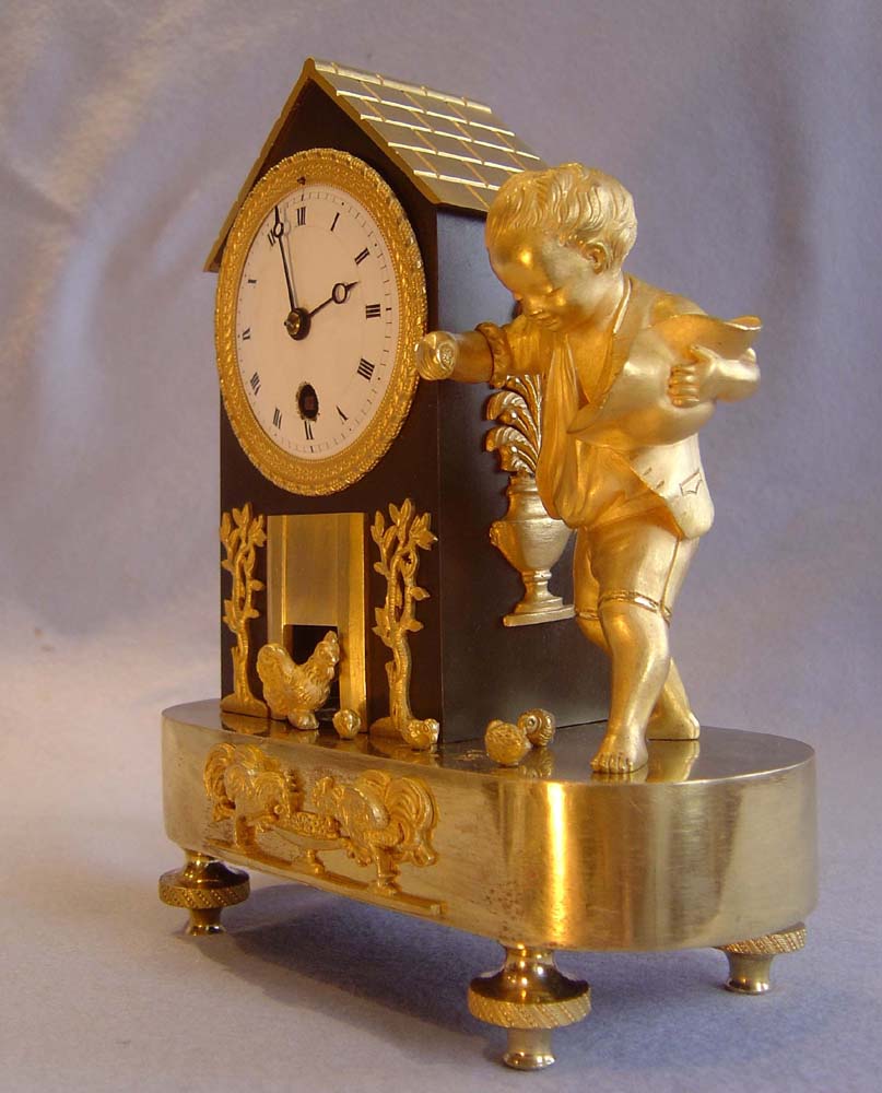 Antique French Empire genre clock of boy feeding chickens.