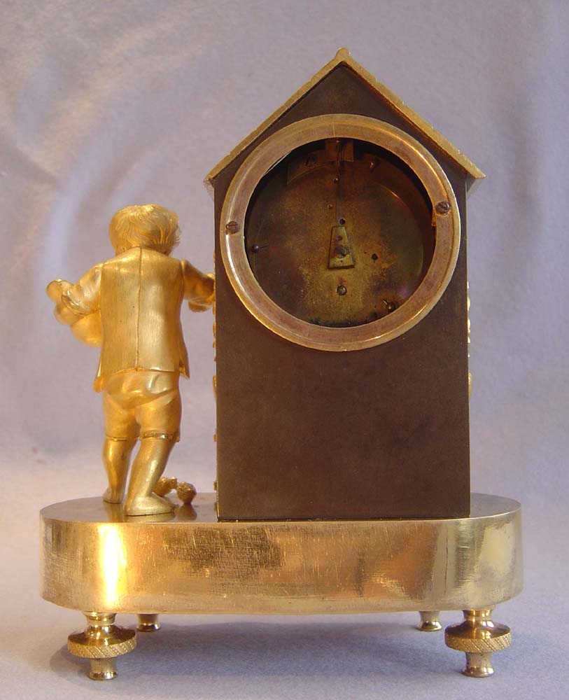 Antique French Empire genre clock of boy feeding chickens.