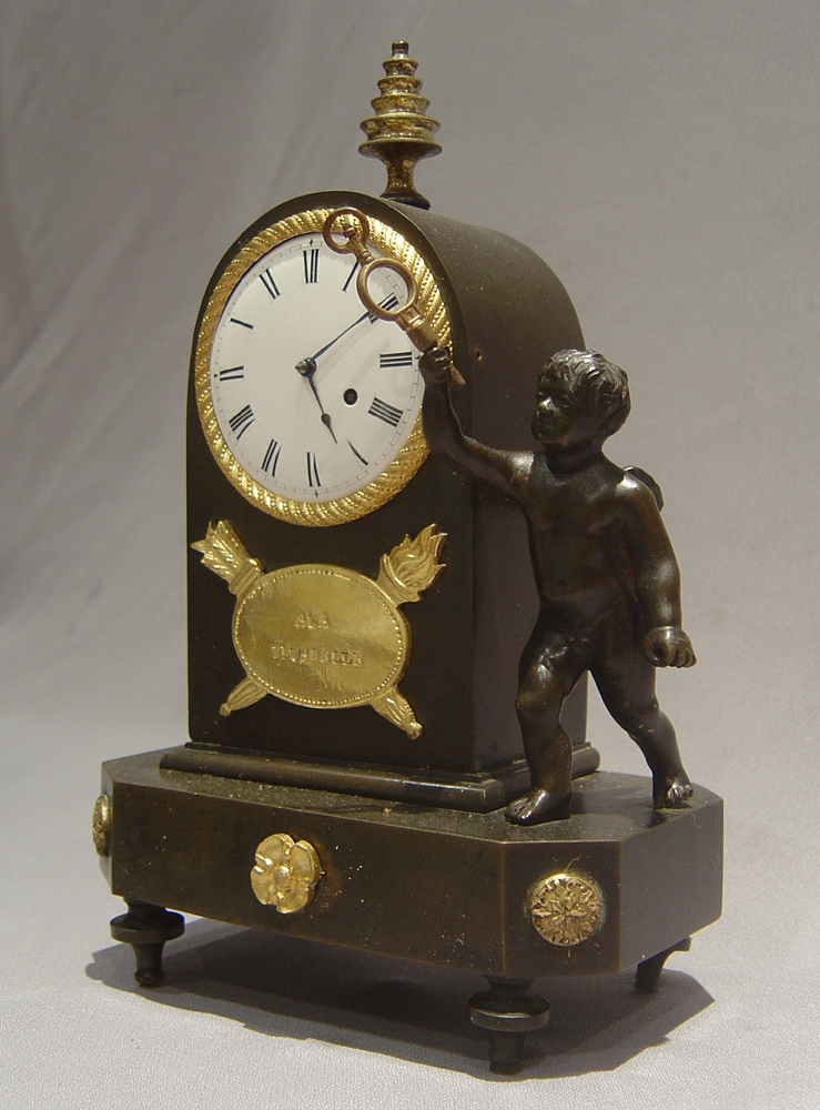 English Regency antique miniature mantel clock in patinated bronze and ormolu.