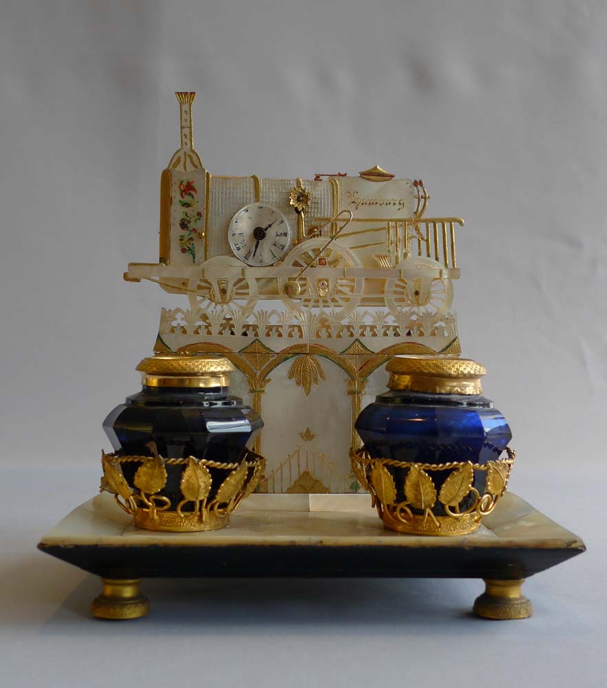 Antique Palais Royal Zapler clock in locomotive form marked Hamburg set on ormolu mounted desk set.